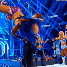 a woman in a wrestling ring with a sign that says down