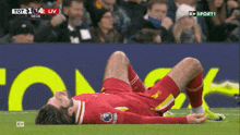 a soccer player is laying on the ground during a game sponsored by k + sport 1