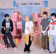 a group of young men are standing in front of a stack of boxes and a sign that says ' sony ' on it