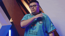 a man wearing a riyadh season jersey stands in front of a blue wall