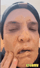 a close up of a person 's face with creamy written on the bottom right