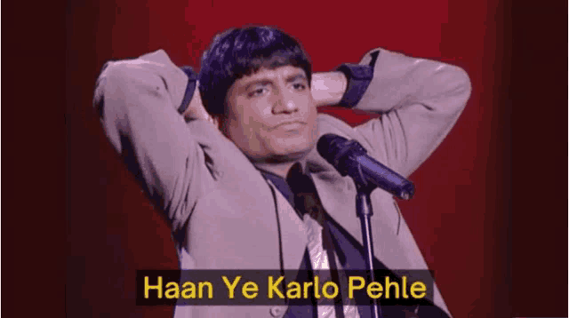 a man stands in front of a microphone with the words haan ye karlo pehle written below him