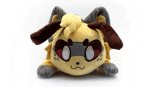 a stuffed animal with a yellow head and brown ears is laying on a white surface