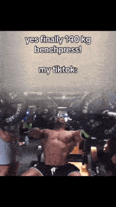 a man is lifting weights in a gym with a caption that reads yes finally 140 kg benchpress my tiktok