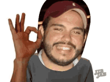 a man with a beard wearing a hat giving an ok sign