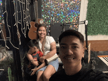 a man and a woman are posing for a picture with a guitar behind them