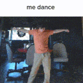 a man in an orange shirt is dancing in a room with the words me dance above him