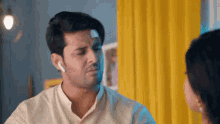 a man with a bandage on his forehead is talking to a woman .
