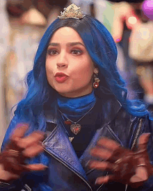 a woman with blue hair wearing a tiara and a leather jacket