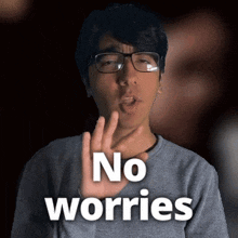 a man wearing glasses says no worries in front of a dark background
