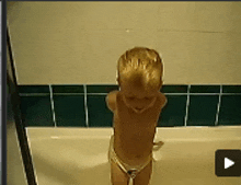a little boy in a bathtub with a play button