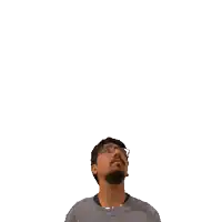 a man with a beard and glasses looks up at the number 20