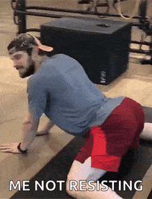 a man is doing stretching exercises on a yoga mat with the words `` me not resisting '' above him .