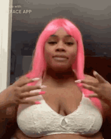 a woman wearing a pink wig and a white bra