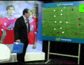a man in a suit is standing in front of a soccer board that says movistar