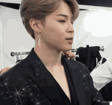 a close up of a person wearing earrings and a black jacket