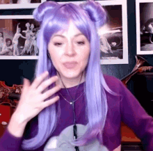 a woman with purple hair is wearing headphones and a purple shirt .