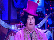 a man in a pink top hat sits in front of a sign that says star