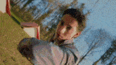 a young man is throwing a frisbee in the air while standing in the grass .