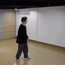 a man in a black shirt and grey pants is standing in a room with a sign that says trinity entertainment