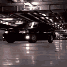 a car is parked in a parking garage under a sign that reads exit
