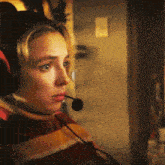 a woman wearing headphones and a microphone looks to her left