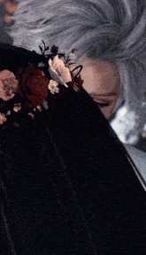 a close up of a person wearing a black dress with flowers on it