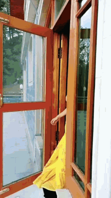 a woman in a yellow dress is walking through a door