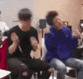 a blurry picture of two men sitting next to each other in chairs .