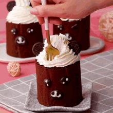 a person is using a fork to decorate a chocolate cake in the shape of a teddy bear