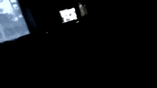 a blurred image of a dark room with a few lights on