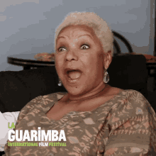 a woman sitting on a couch with her mouth open and the words guarimba international film festival below her