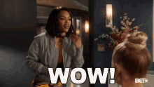 a woman in a grey jacket says wow