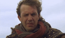 a man with a scarf around his neck is looking through a telescope with his eyes closed