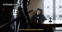 a woman is sitting at a table with a sword in her hand and a man standing behind her .