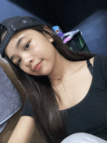 a girl wearing a black shirt and a hat with the word reebok on the front