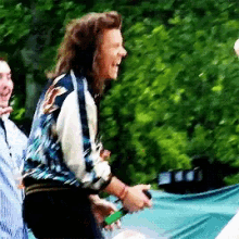 a man with long hair wearing headphones is laughing