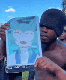 a shirtless man is holding up a drawing of a wolf with the words " you are so cute " written on it