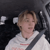 a man wearing a hoodie that says rivimtow on it is sitting in a car
