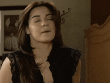 a woman in a black top is making a funny face .