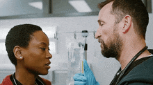 a man and a woman are talking in a hospital room .