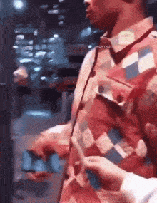 a man in a colorful shirt is holding a piece of paper