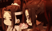 a couple of anime characters standing next to each other holding a flower .