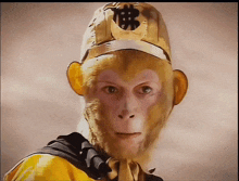 a close up of a monkey wearing a gold hat with a chinese symbol on it