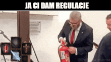 a man in a suit and tie is lighting a fire extinguisher with a cross on it