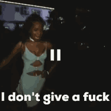 a woman in a blue dress is standing in the dark and says `` i don 't give a fuck ''