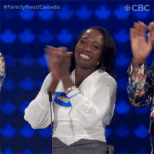 a woman wearing a name tag that says janet applauds