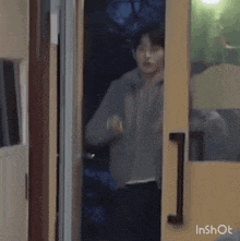 a person is standing in a doorway with a green speech bubble behind them