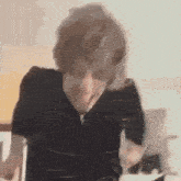 a man in a black shirt is making a funny face .
