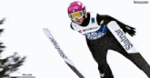 a skier wearing a helmet that says hot laque is flying through the air